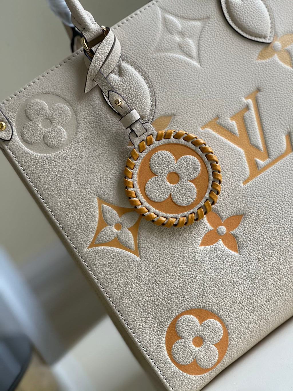 Sac LV Onthego MM 35, garniture en cuir de vachette crème 